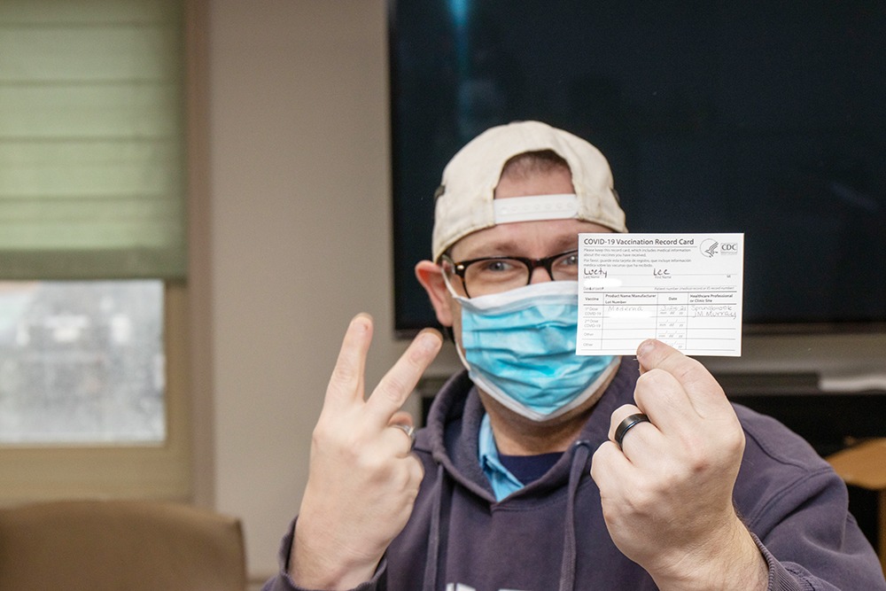 STC Member Lee Leuty enthusiastically holds up his vaccine card.