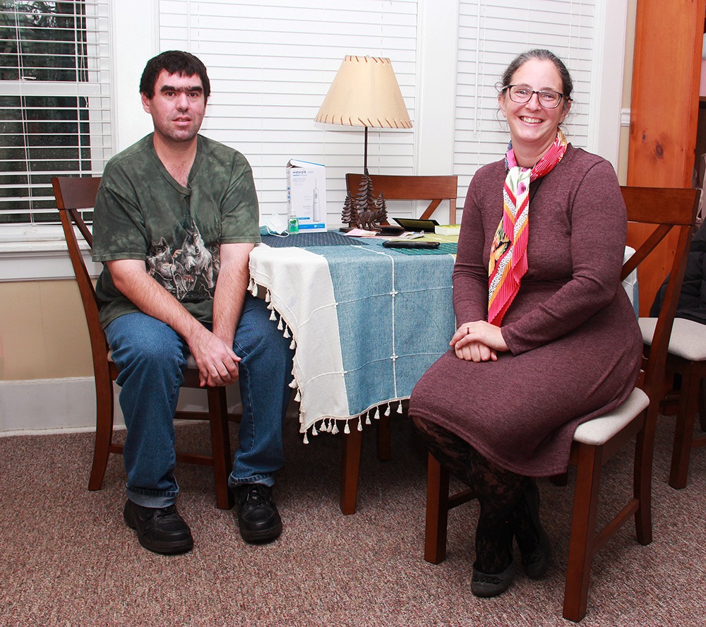 Patrick Toomey and his Care Manager, Ellen Pernat, sit at Patrick's dining table in his apartment in Oneonta. 